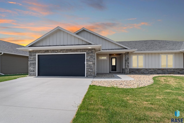 view of front facade featuring an attached garage, concrete driveway, stone siding, board and batten siding, and a front yard