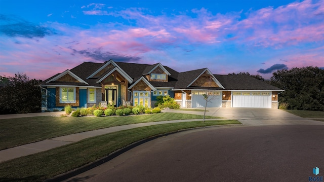 craftsman-style home featuring a garage and a yard