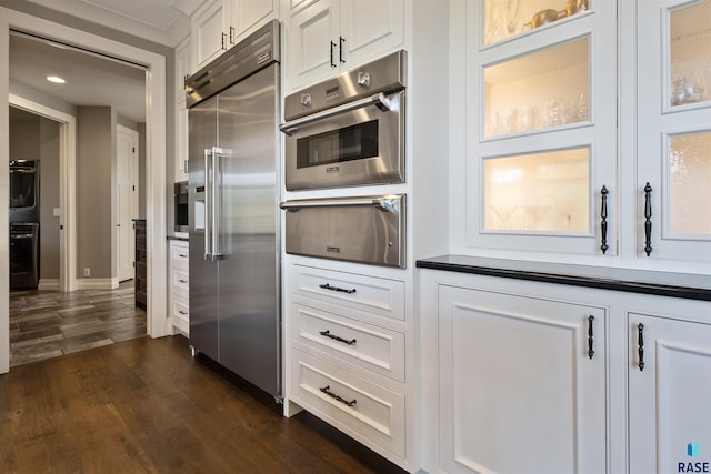 kitchen featuring double oven, stainless steel built in fridge, and white cabinets