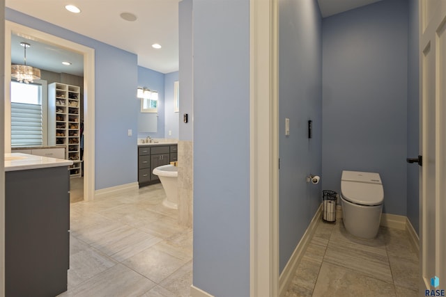bathroom featuring a washtub, vanity, and a chandelier