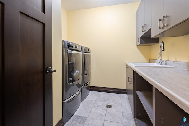 clothes washing area with cabinets, independent washer and dryer, and sink
