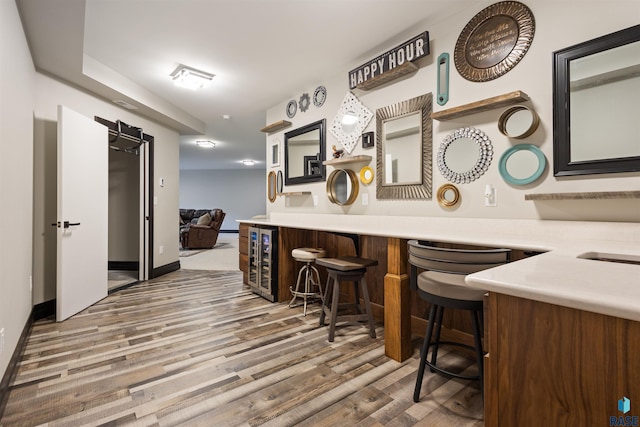 bar featuring hardwood / wood-style floors and beverage cooler