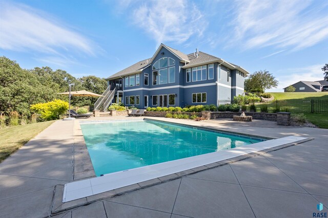 back of house featuring a fenced in pool and a patio