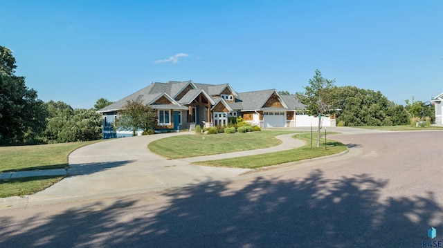 craftsman-style house featuring a garage and a front lawn