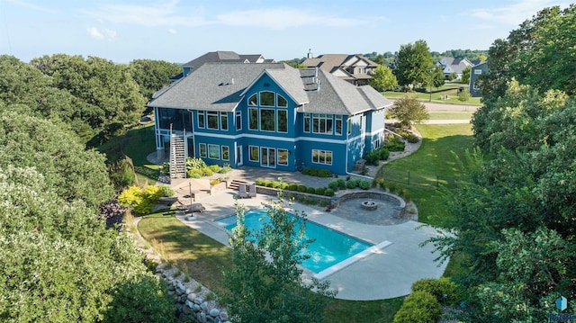 rear view of house featuring a lawn and a patio
