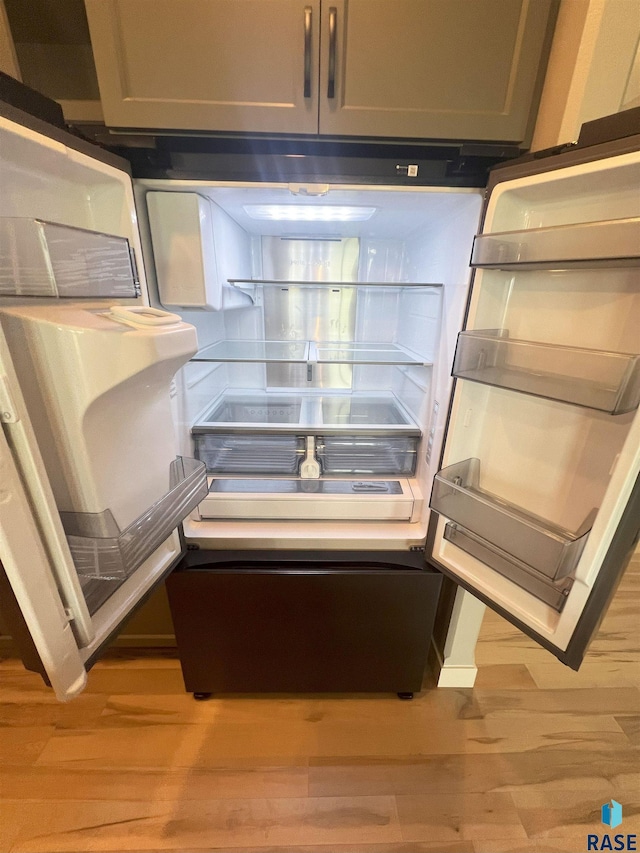 interior details featuring gray cabinetry, refrigerator, and light hardwood / wood-style flooring