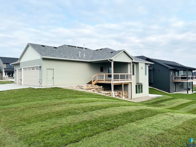 rear view of house featuring a garage and a yard