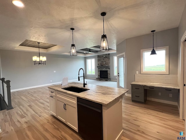 kitchen featuring white cabinetry, hanging light fixtures, sink, and black dishwasher