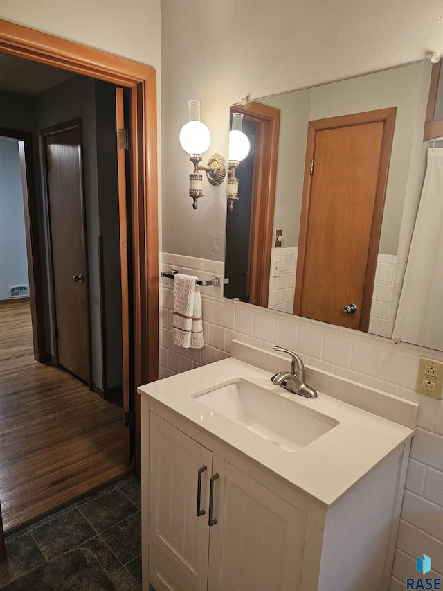 bathroom featuring tasteful backsplash, vanity, and tile walls