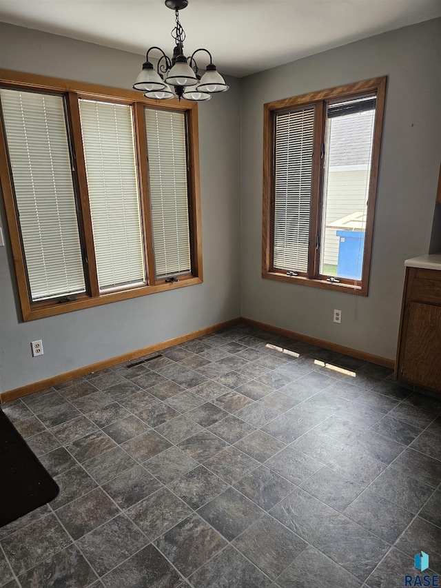 unfurnished dining area with a chandelier