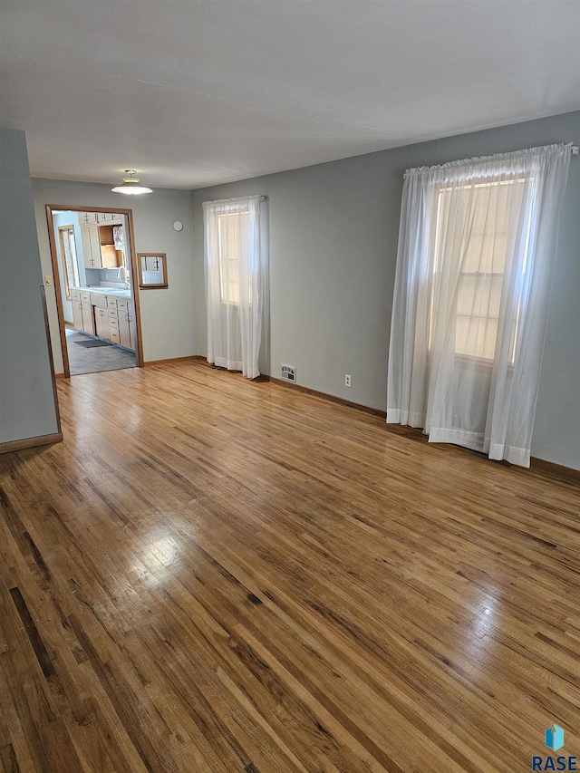 unfurnished living room with sink and hardwood / wood-style floors