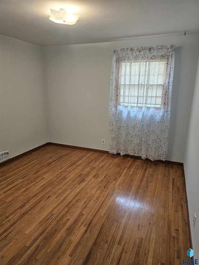 empty room with hardwood / wood-style flooring