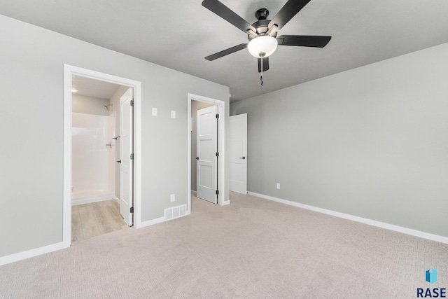 unfurnished bedroom featuring light carpet, ensuite bath, and ceiling fan