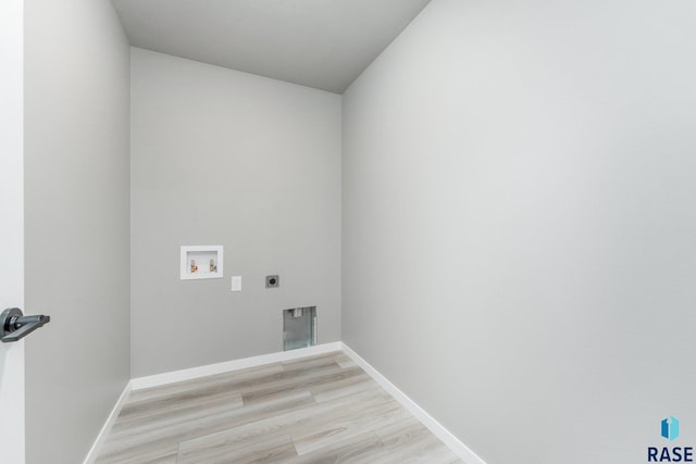 clothes washing area with washer hookup, hookup for an electric dryer, and light wood-type flooring