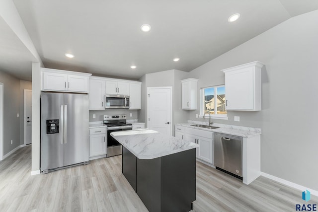 kitchen featuring lofted ceiling, sink, white cabinetry, a center island, and stainless steel appliances