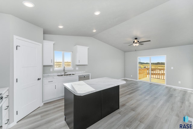 kitchen with white cabinetry, sink, a center island, stainless steel dishwasher, and plenty of natural light