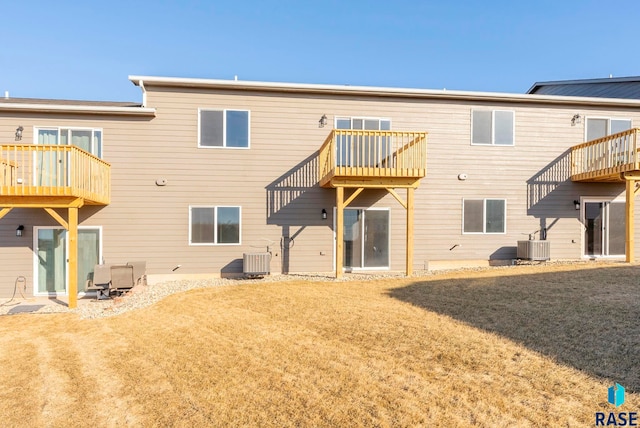 back of house with cooling unit and a yard