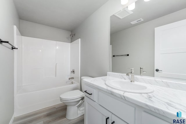 full bathroom with hardwood / wood-style flooring, vanity, bathtub / shower combination, and toilet