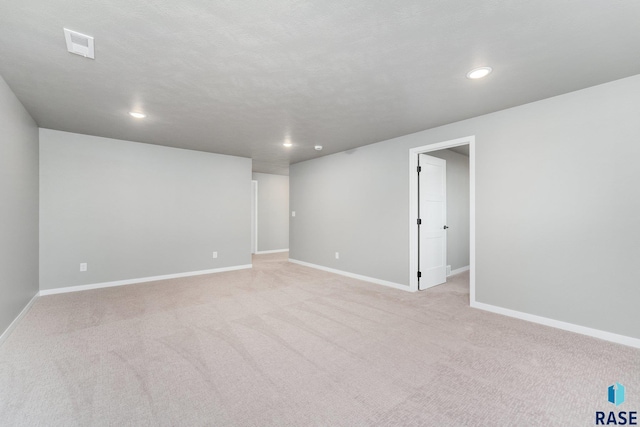 carpeted empty room with a textured ceiling