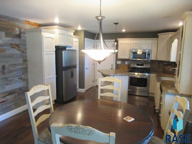 kitchen with decorative backsplash, hanging light fixtures, stainless steel appliances, a sink, and recessed lighting