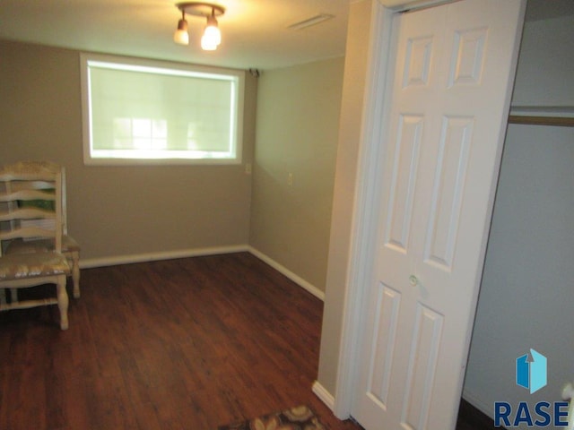 interior space featuring dark wood-style flooring and baseboards