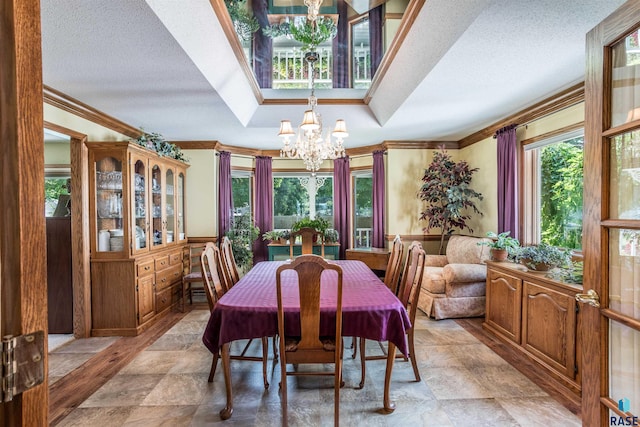 dining space with ornamental molding, a notable chandelier, and light tile patterned floors