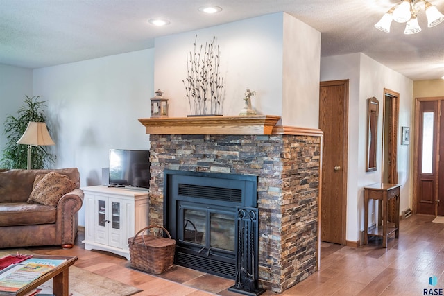 living room with a fireplace, a textured ceiling, and hardwood / wood-style floors