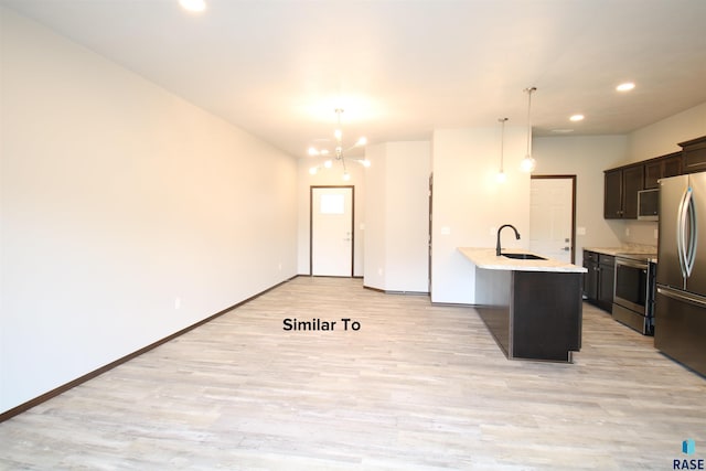 kitchen featuring electric stove, kitchen peninsula, stainless steel refrigerator, light hardwood / wood-style floors, and decorative light fixtures