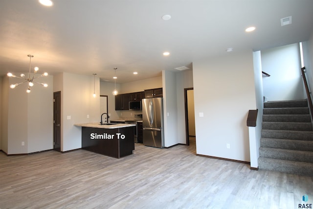 kitchen with stainless steel appliances, pendant lighting, kitchen peninsula, light hardwood / wood-style floors, and dark brown cabinetry