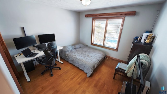 bedroom featuring hardwood / wood-style flooring and a textured ceiling