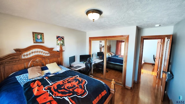 bedroom featuring dark wood-type flooring, a textured ceiling, and a closet