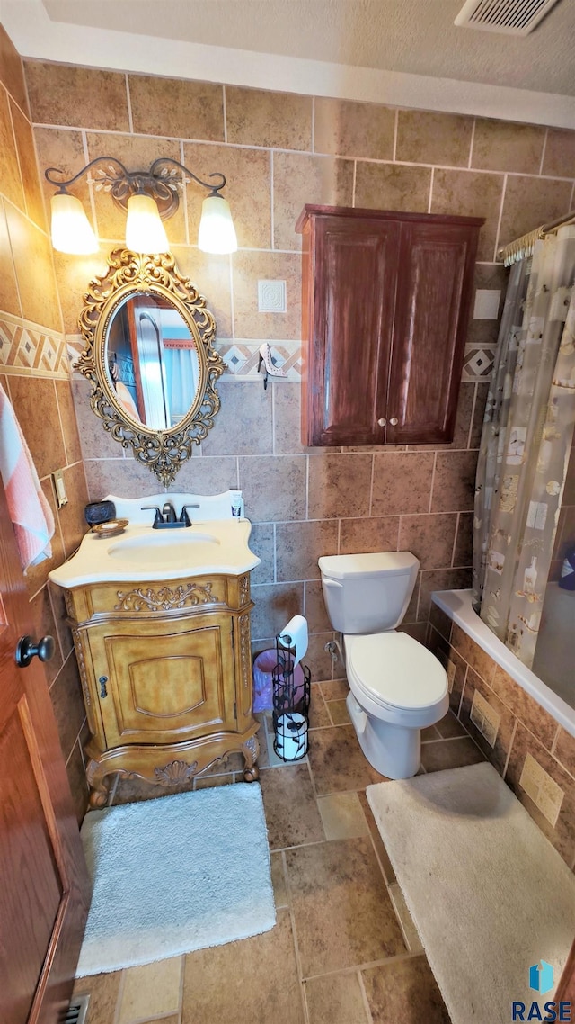 full bathroom featuring shower / tub combo with curtain, vanity, toilet, and tile walls