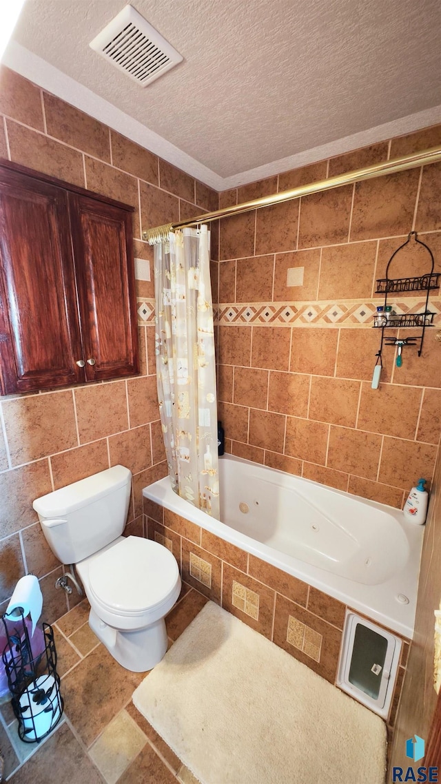 bathroom featuring tile walls, shower / bathtub combination with curtain, a textured ceiling, and toilet