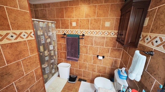 bathroom featuring toilet, a shower with shower curtain, and tile walls