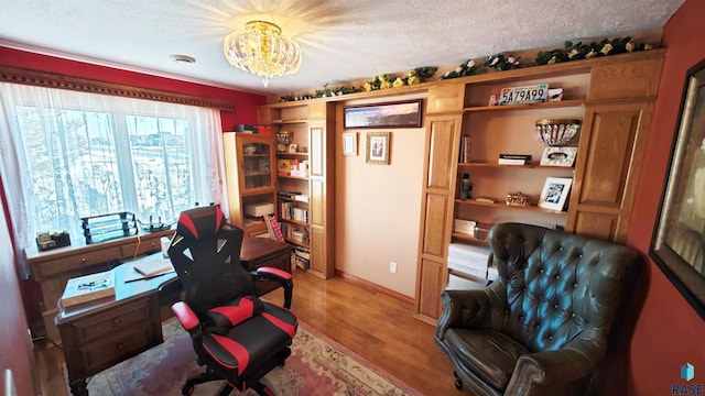 office featuring light hardwood / wood-style floors, a textured ceiling, and a notable chandelier