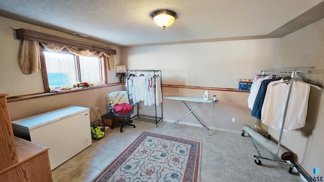 bedroom with a textured ceiling and refrigerator