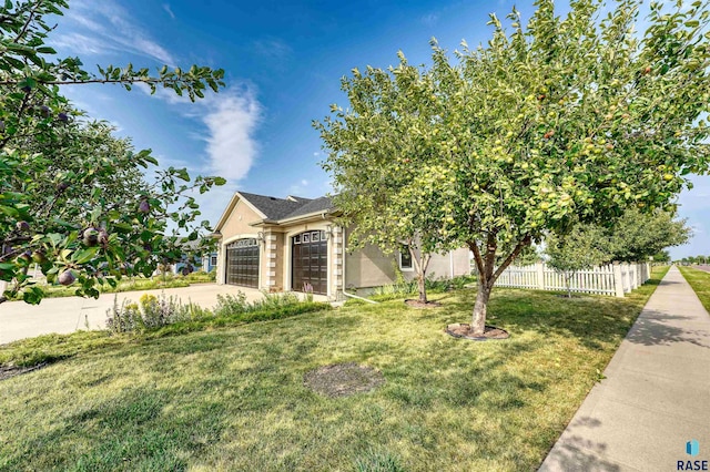 view of property hidden behind natural elements featuring a garage and a front yard