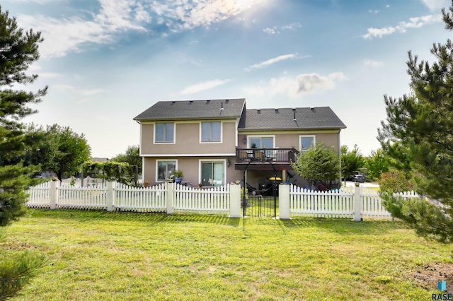 back of house featuring a wooden deck and a yard