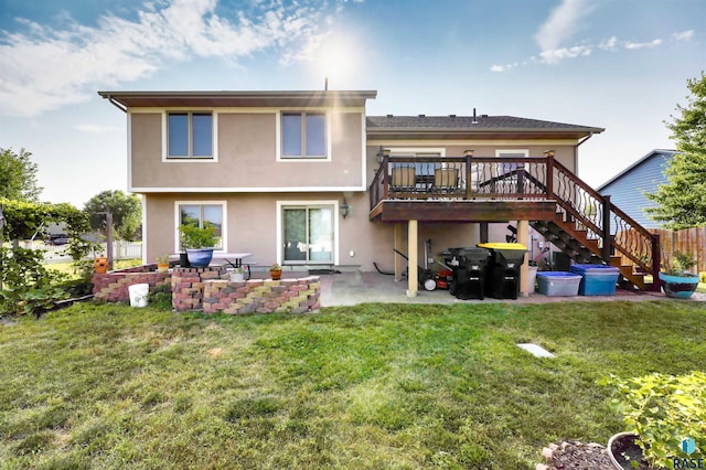 back of house featuring a wooden deck, a yard, and a patio area