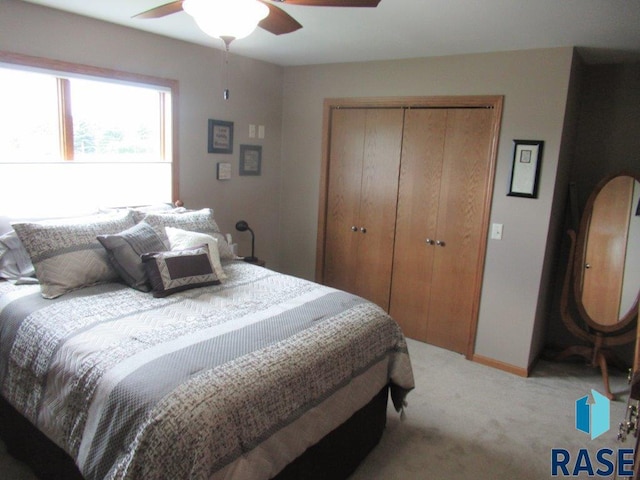 bedroom with ceiling fan, carpet flooring, and a closet