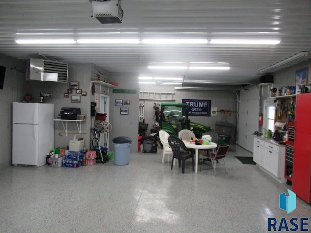 garage with white fridge and a garage door opener