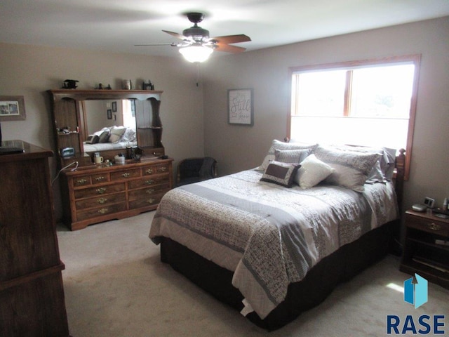 bedroom featuring light colored carpet and ceiling fan