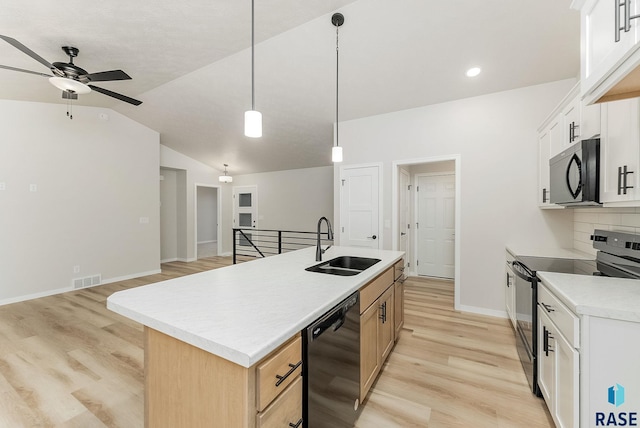 kitchen featuring lofted ceiling, sink, white cabinets, a kitchen island with sink, and black appliances