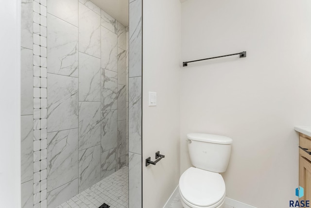 bathroom featuring tiled shower, vanity, and toilet