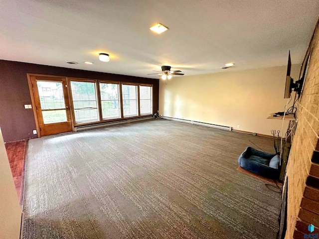 carpeted empty room featuring a baseboard heating unit and ceiling fan