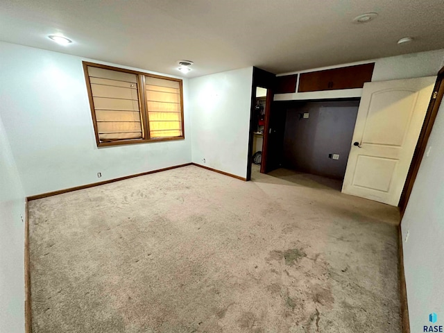 unfurnished bedroom with a closet and light colored carpet