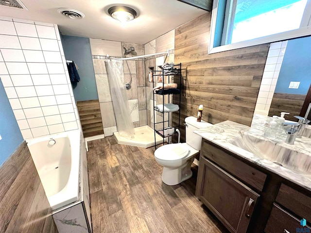 bathroom with vanity, wood walls, wood-type flooring, and toilet