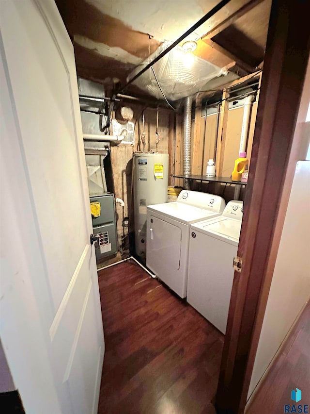 laundry room featuring dark hardwood / wood-style floors, washing machine and clothes dryer, and water heater