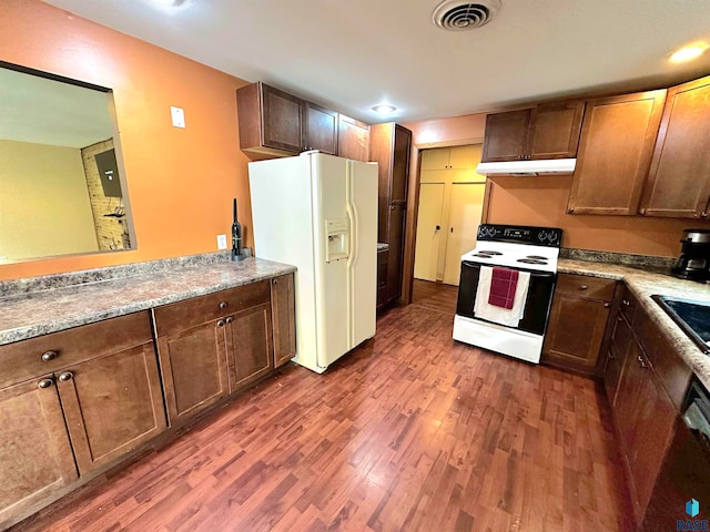 kitchen featuring dark wood-type flooring, white appliances, and sink