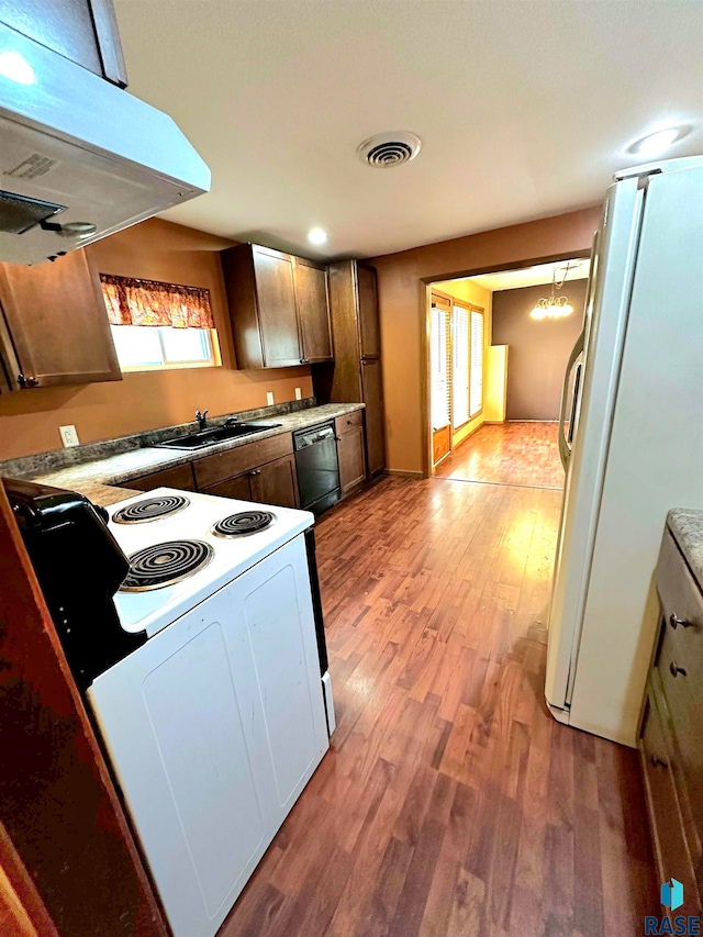 kitchen featuring extractor fan, white appliances, light wood-type flooring, and plenty of natural light